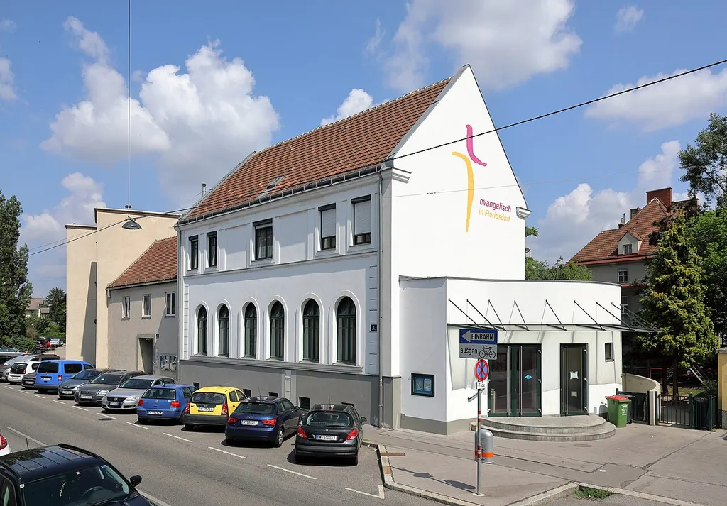 Südostansicht der evangelischen Pfarrkirche Floridsdorf an der Adresse Weisselgasse 1 im 21. Wiener Gemeindebezirk Floridsdorf.Der Betsaal bzw. die Kirche mit der darüberliegenden Pfarrerswohnung wurde ab 1904 nach den Plänen des Architekten Gustav Knell errichtet und am 28. Jänner 1906 geweiht. Der Bau wies secessionistische Züge und Einflüsse des Heimatstils auf, wobei die Fassade 1944 zerstört wurde. Im Jahr 2002 wurde der Eingangsbereich der Kirche von Grund auf neu gestaltet.
