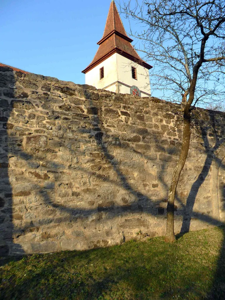 Dombühl-Kirchhofmauer im Süden mit Werksteinen im Mauersteinverband von der Feldseite mit Kirchturm im Glockengeschoß-25032012