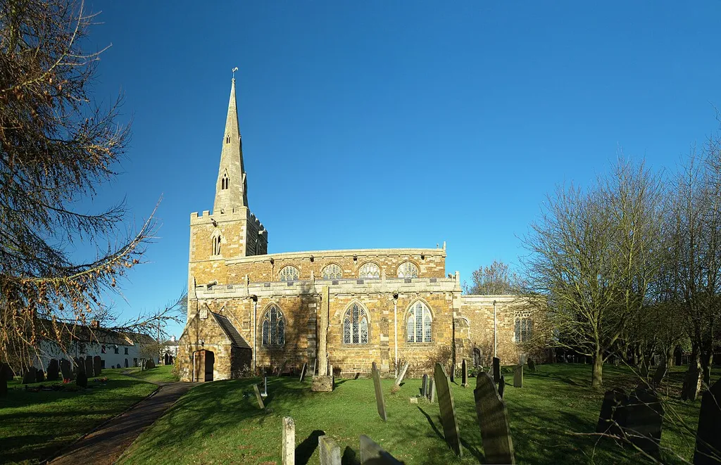 St Peter's parish church, Tilton on the Hill, Leicestershire. The headless cross in the foreground is a scheduled monument