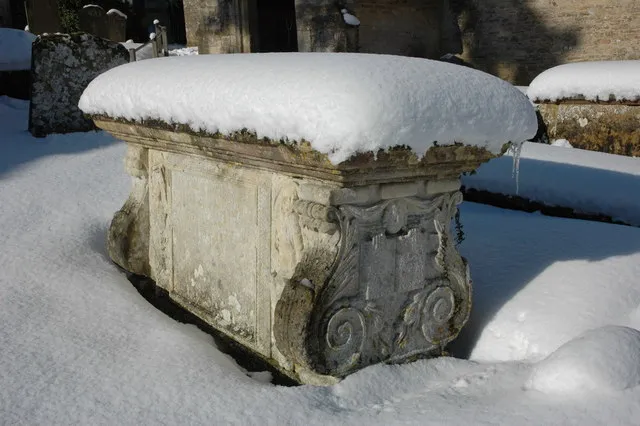 Chest tomb of Robert and Edward Briggs in St Mary's parish churchyard, Cowley, Gloucestershire, in snow