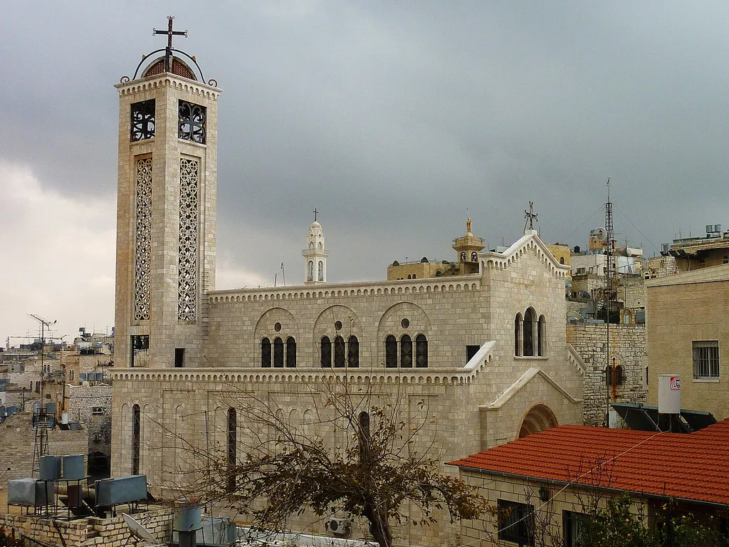 North side of the Greek Catholic Melkite Church of the Theotokos, with the tower of Saint Mary's Syriac Orthodox Church in the background.
