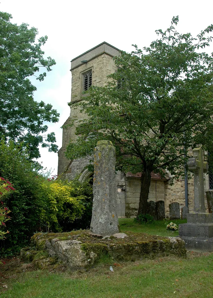 Holy Trinity parish church, Drayton Parslow, Buckinghamshire: base and broken shaft of churchyard cross, with the 15th-century west tower of the church in the background