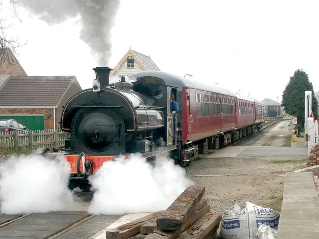 Lincolnshire Wolds Railway, Ludborough. The train heads out, over the railway crossing, on another trip.
