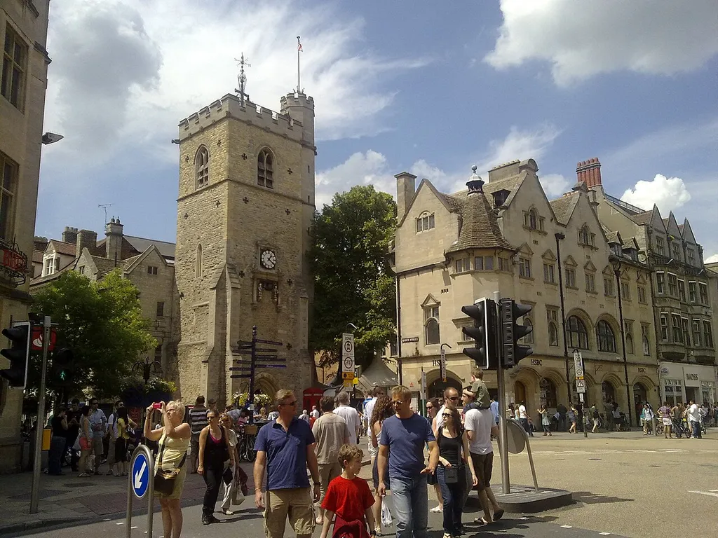 Carfax, Oxford, England: view from St Aldate's Street. On the left is the tower of the former St Martin's parish church. The rest of St Martin's was demolished in 1896. To the right of the tower is 62–65 Cornmarket Street, built in 1896–97 and now a branch of HSBC.