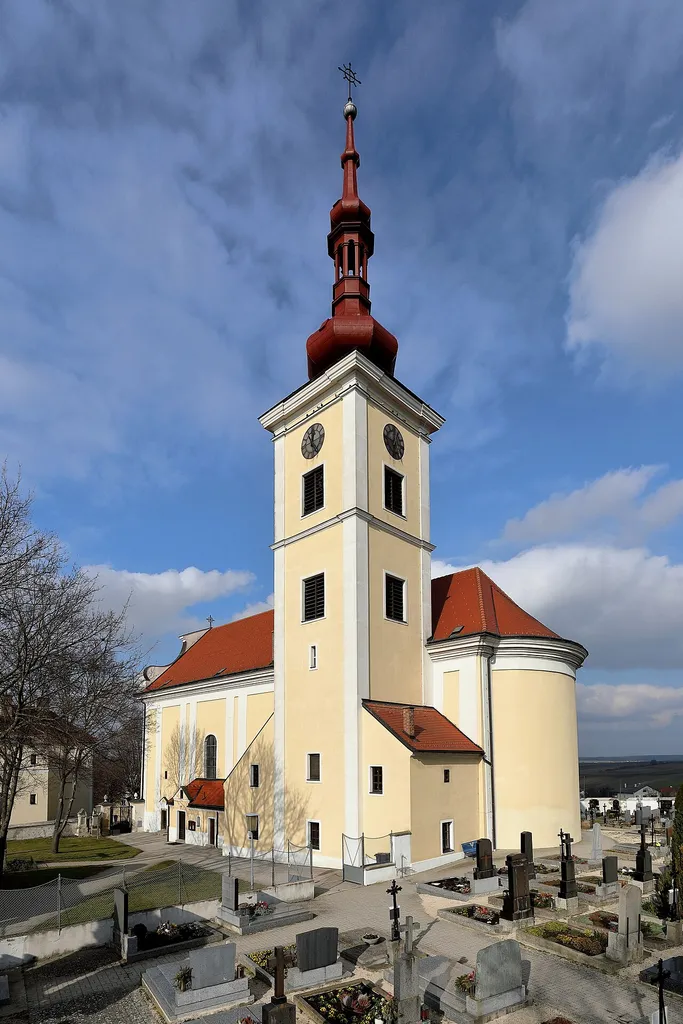 Südansicht der röm.-kath. Pfarrkirche Hl. Kreuz in der niederösterreichischen Marktgemeinde Hohenruppersdorf. Ein in erhöhter Lage von 1788 bis 1790 errichteter barocker Sakralbau mit einem mächtigen Südturm, der im Kern mittelalterlich ist.
